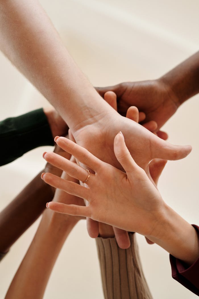 About A close-up of diverse hands joined together symbolizing teamwork, cooperation, and unity indoors.